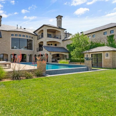 Three separate living features lend to the accessibility to the outdoors and includes a pool house and complete outdoor kitchen.